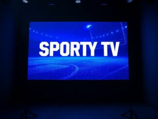 Televizní obrazovka s nápisem Sporty TV v setmělém studiu