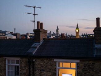 Střešní televizní anténa na britském řadovém domě za soumraku